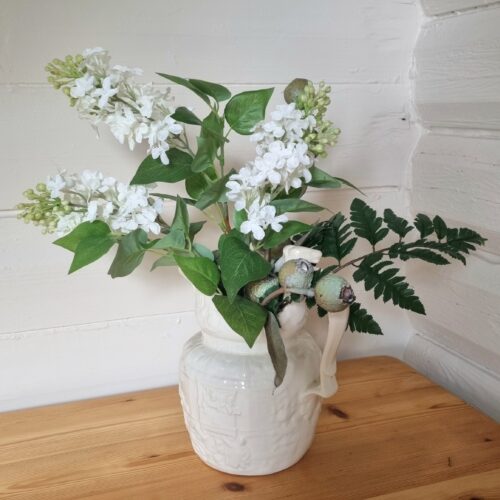 Sød antik servantekande og smukke blomster