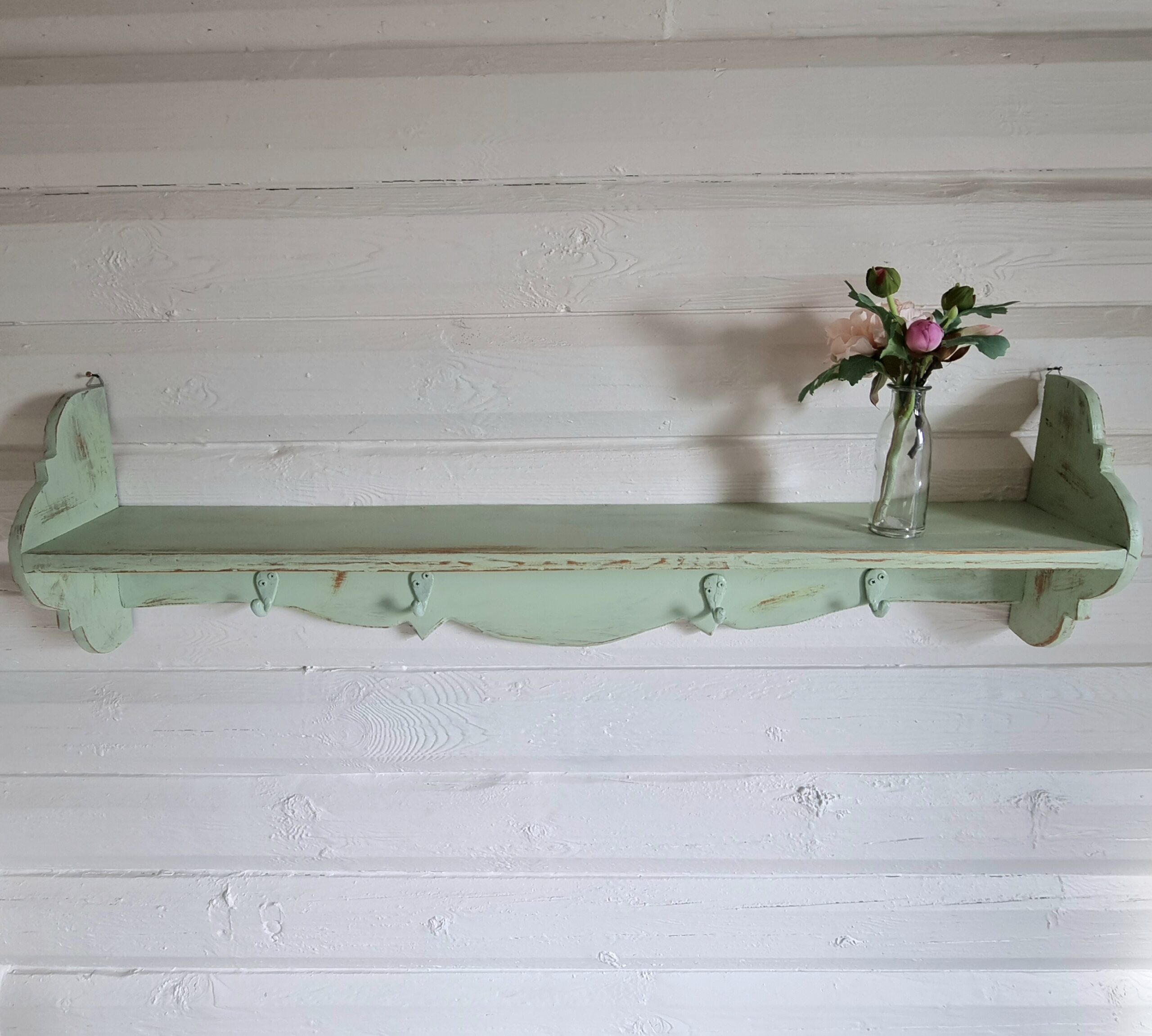 Pastelgrøn hylde med knager