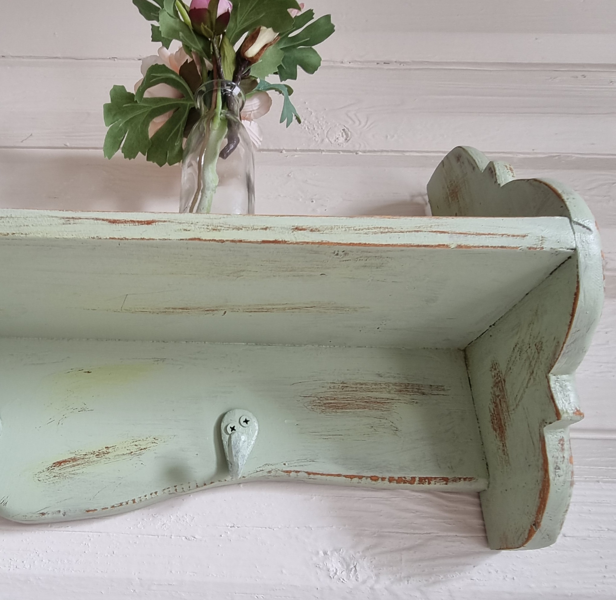 Pastelgrøn hylde med knager