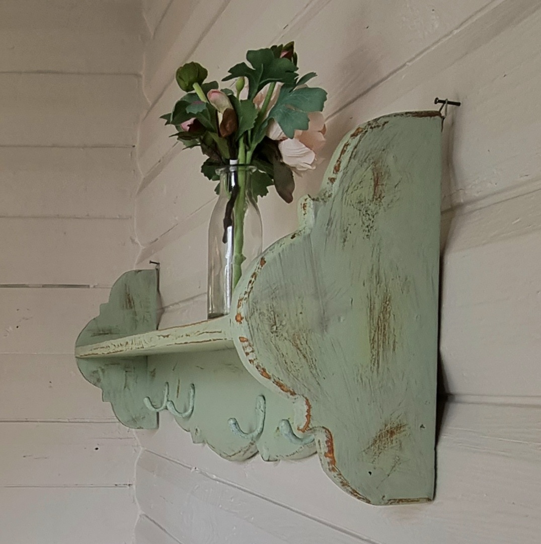 Pastelgrøn hylde med knager