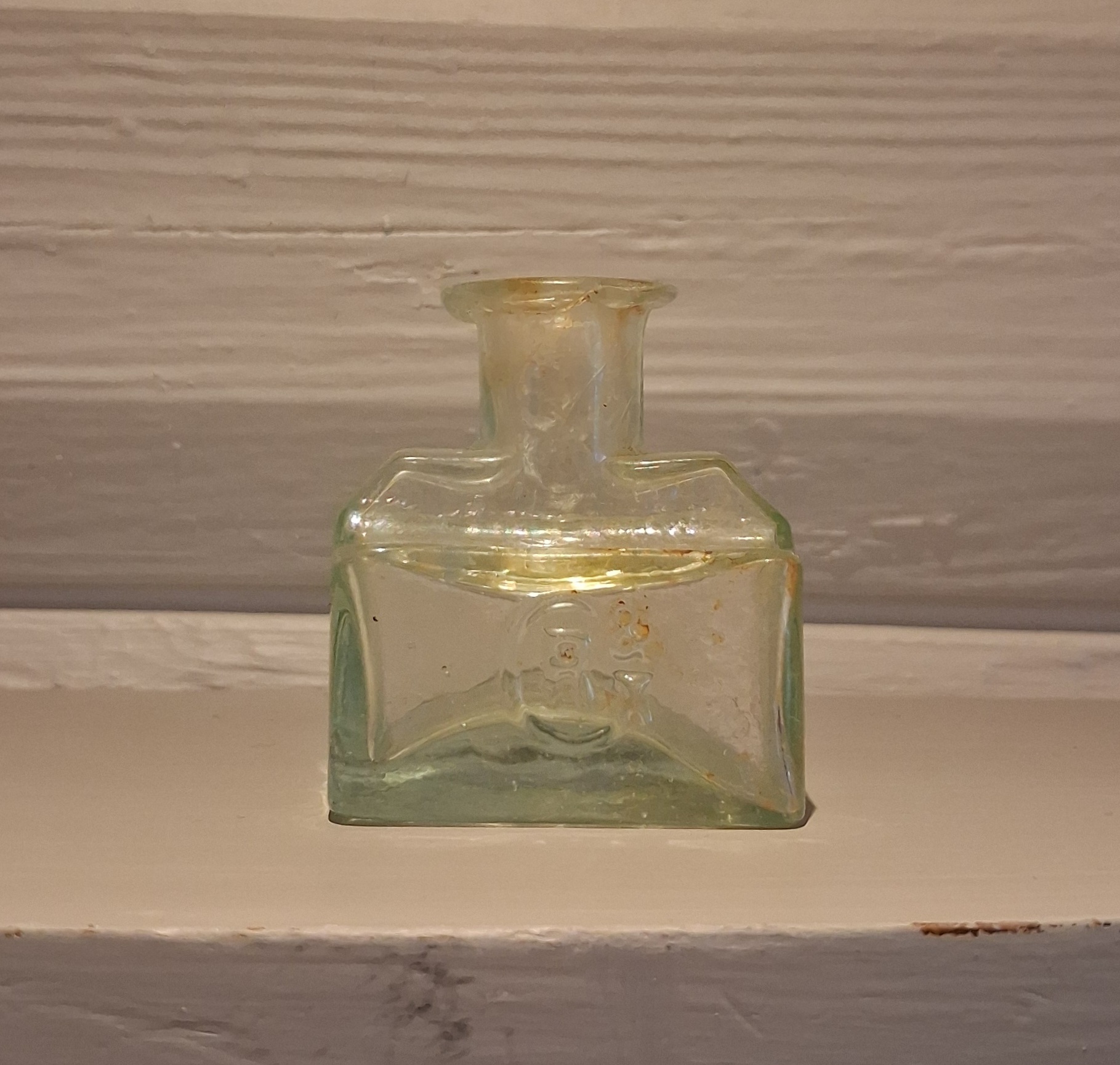 Fin lille gammel blækflaske i grønt glas