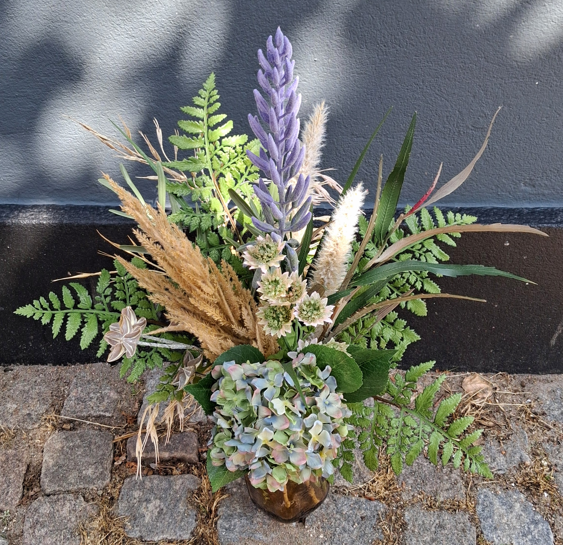 En flot buket med kunstige blomster og grene