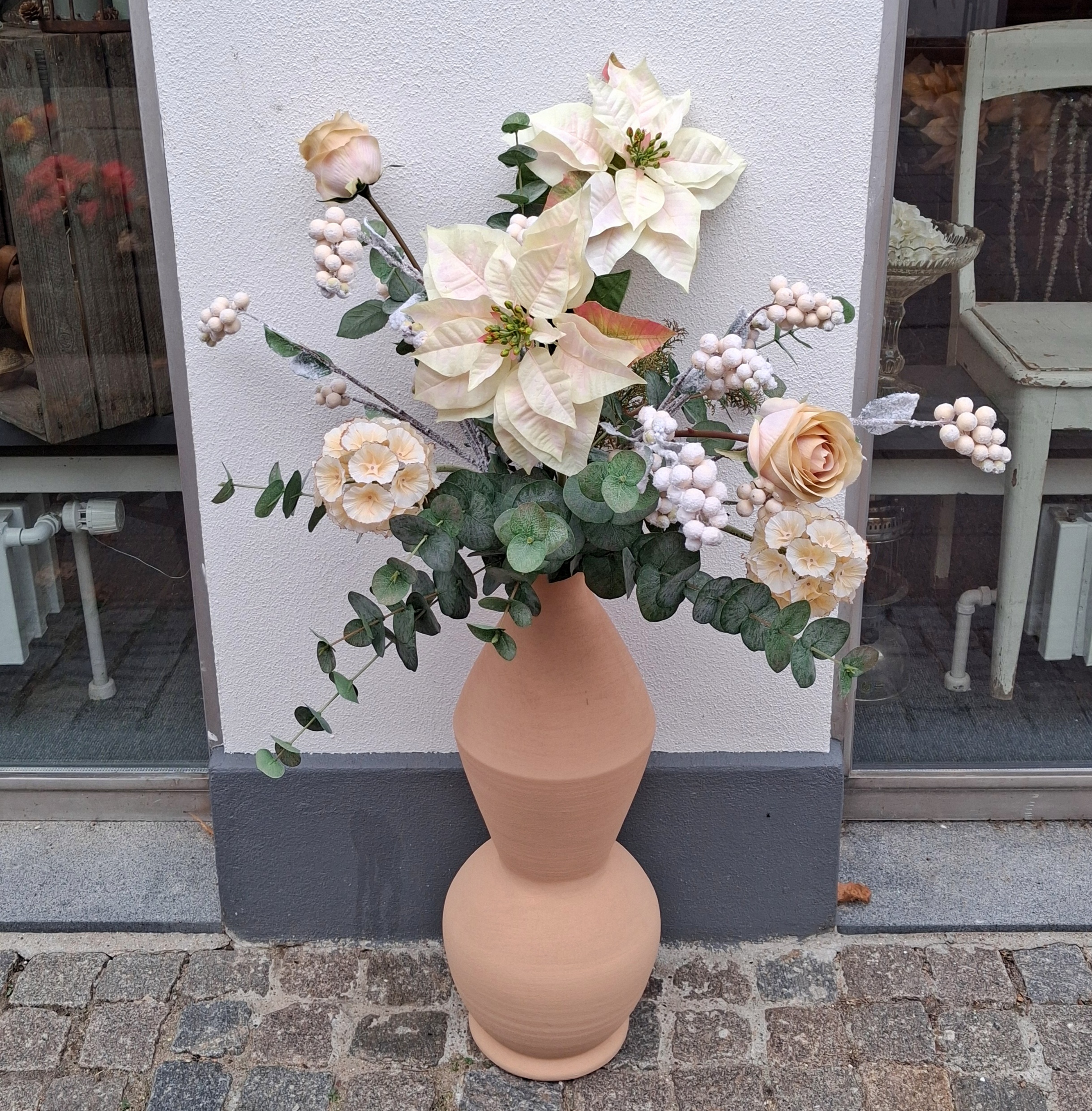 Smukke kunstige blomster i gulvvasen